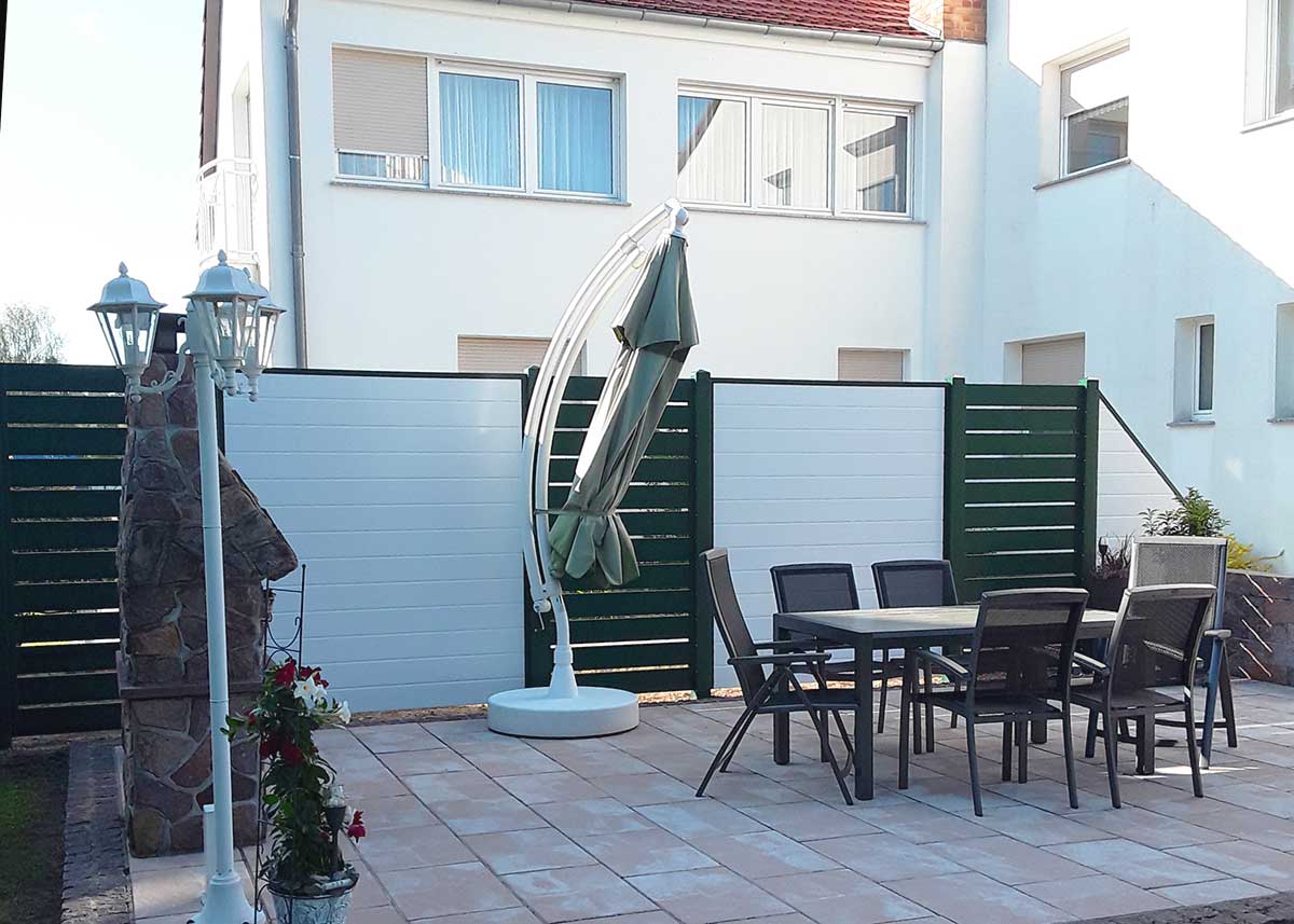 Sichtschutz mit Spaltelemeten, Rhombus-Zaun, in Weiß und Moosgrün, auf der Terrasse