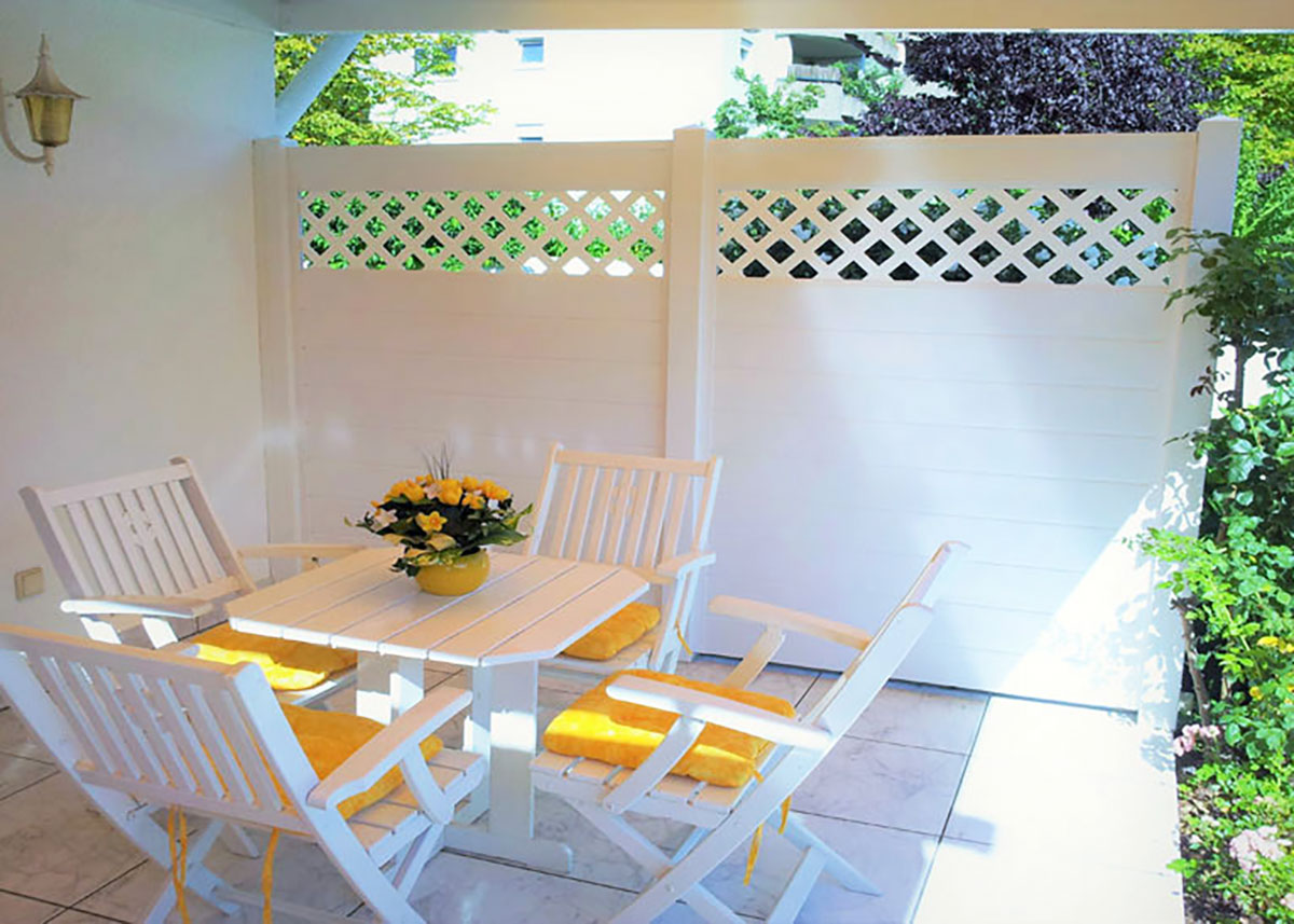 heller Sichtschutz mit Rankgitter in weiß auf kleiner Terrasse
