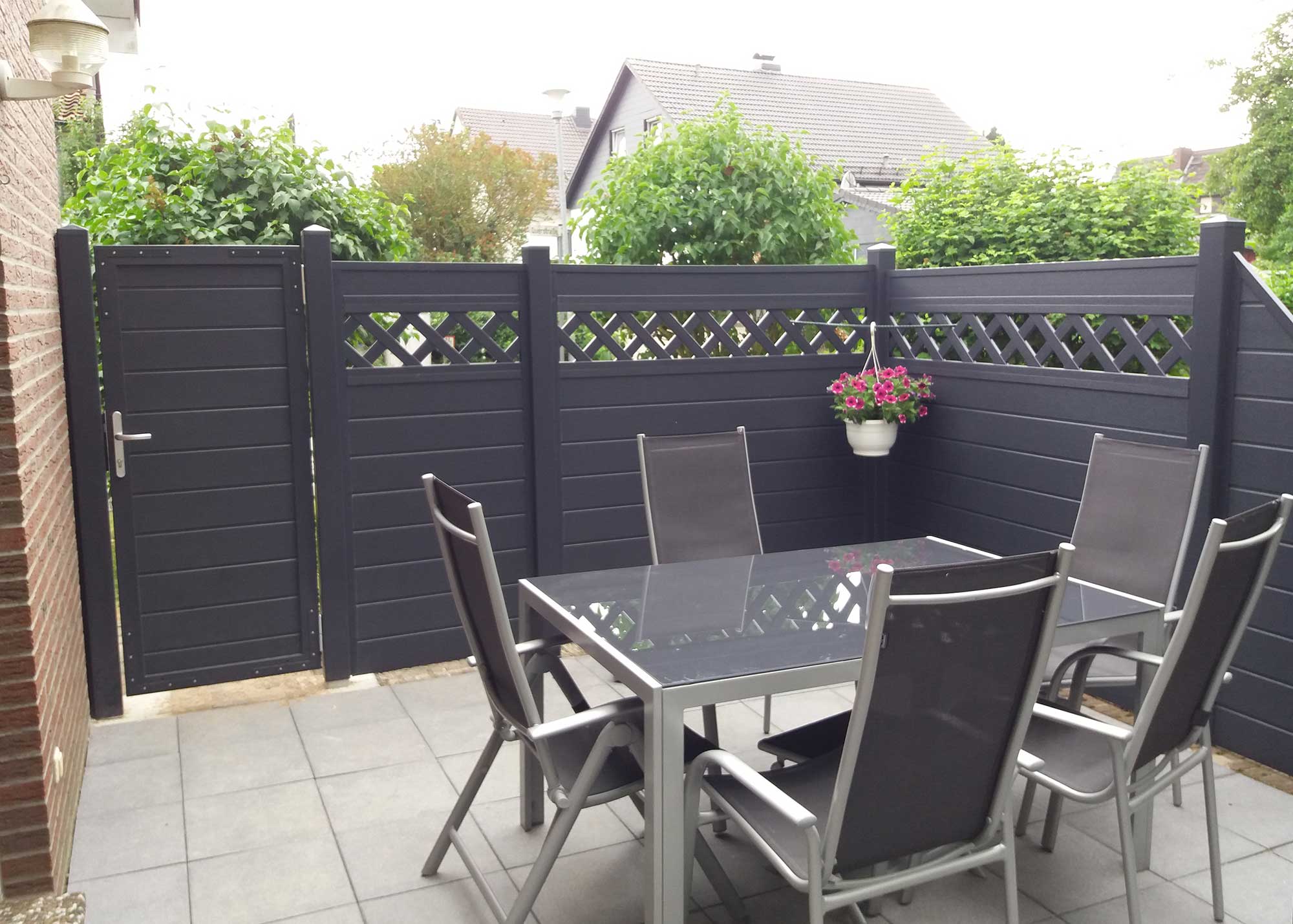 Dichtzaun aus Kunststoff in Anthrazit auf einer Terrasse im Garten mit passender Tür