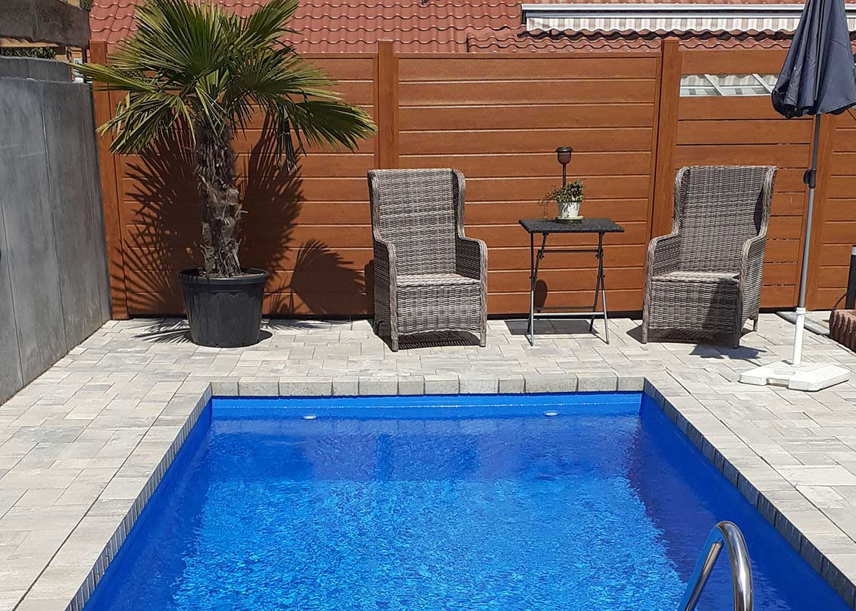 lange Trennwand am Pool mit verschiedenen Elementen in Holzoptik goldige Eiche,