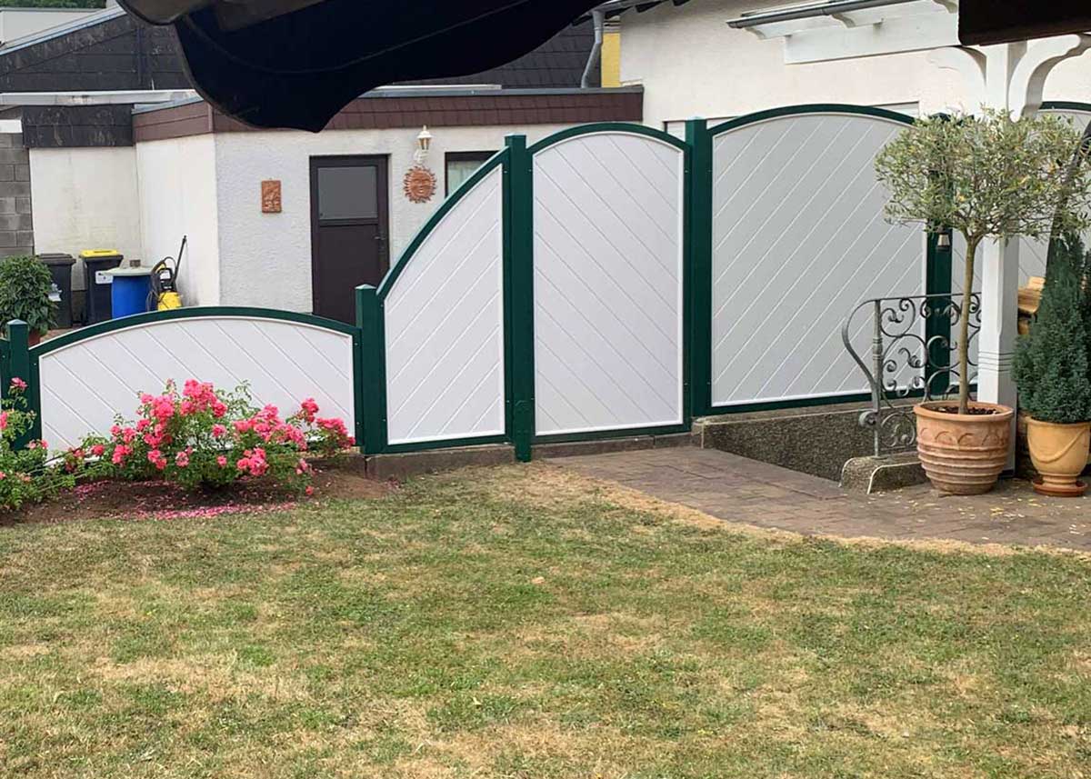 individueller Sichtschutz-Trennwand mit Rundbogen im Garten in Weiß mit grünem Rahmen und Pfosten