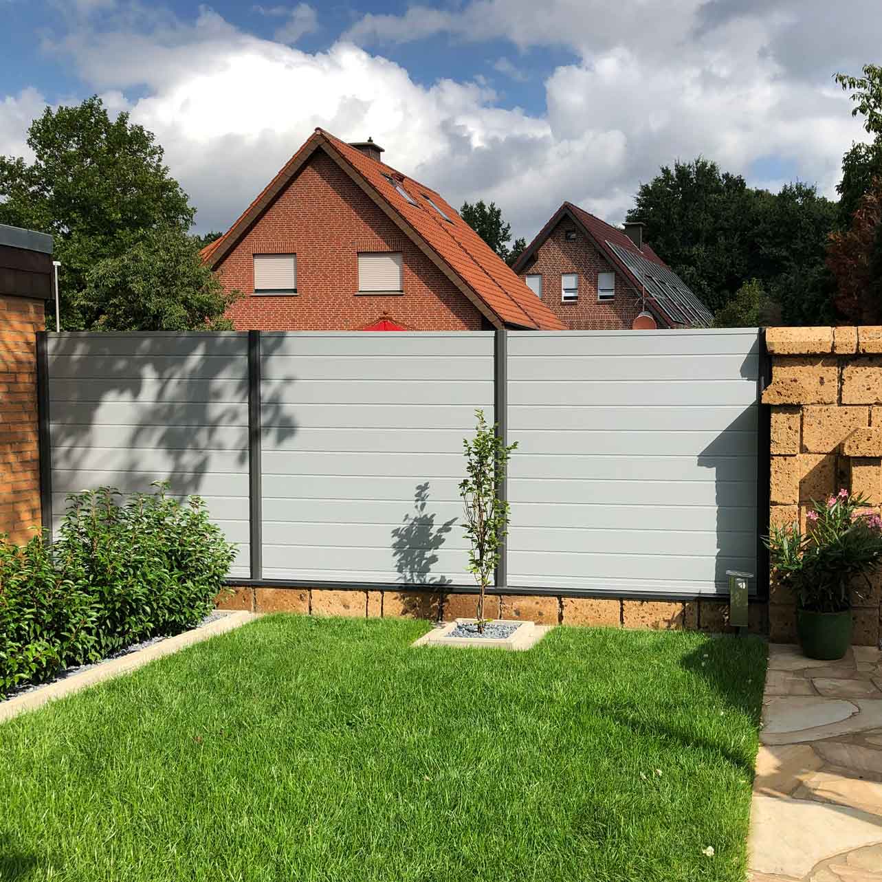 dichte Sichtschutzwand aus Kunststoff in Grau im Garten