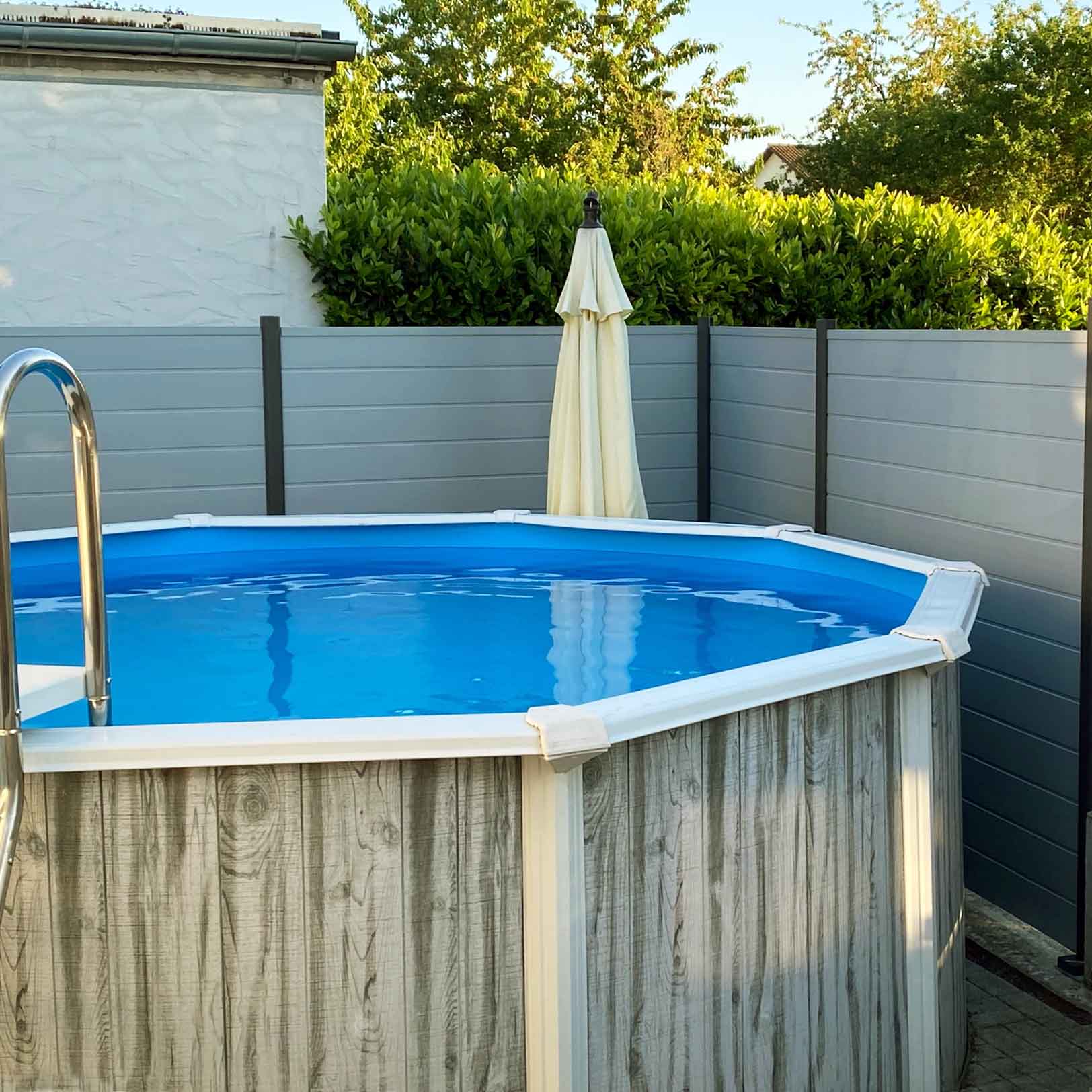 Blickfang Sichtschutzwand um den Pool im Garten aus Kunststoff in Grau