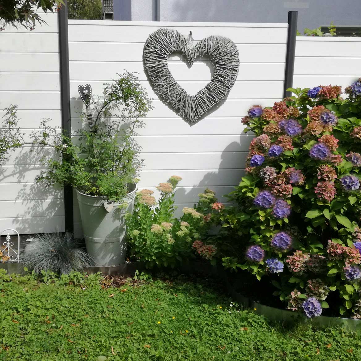 Sichtschutz in weiß aus Kunststoff mit Aluminium Pfosten Landhausstil im Garten