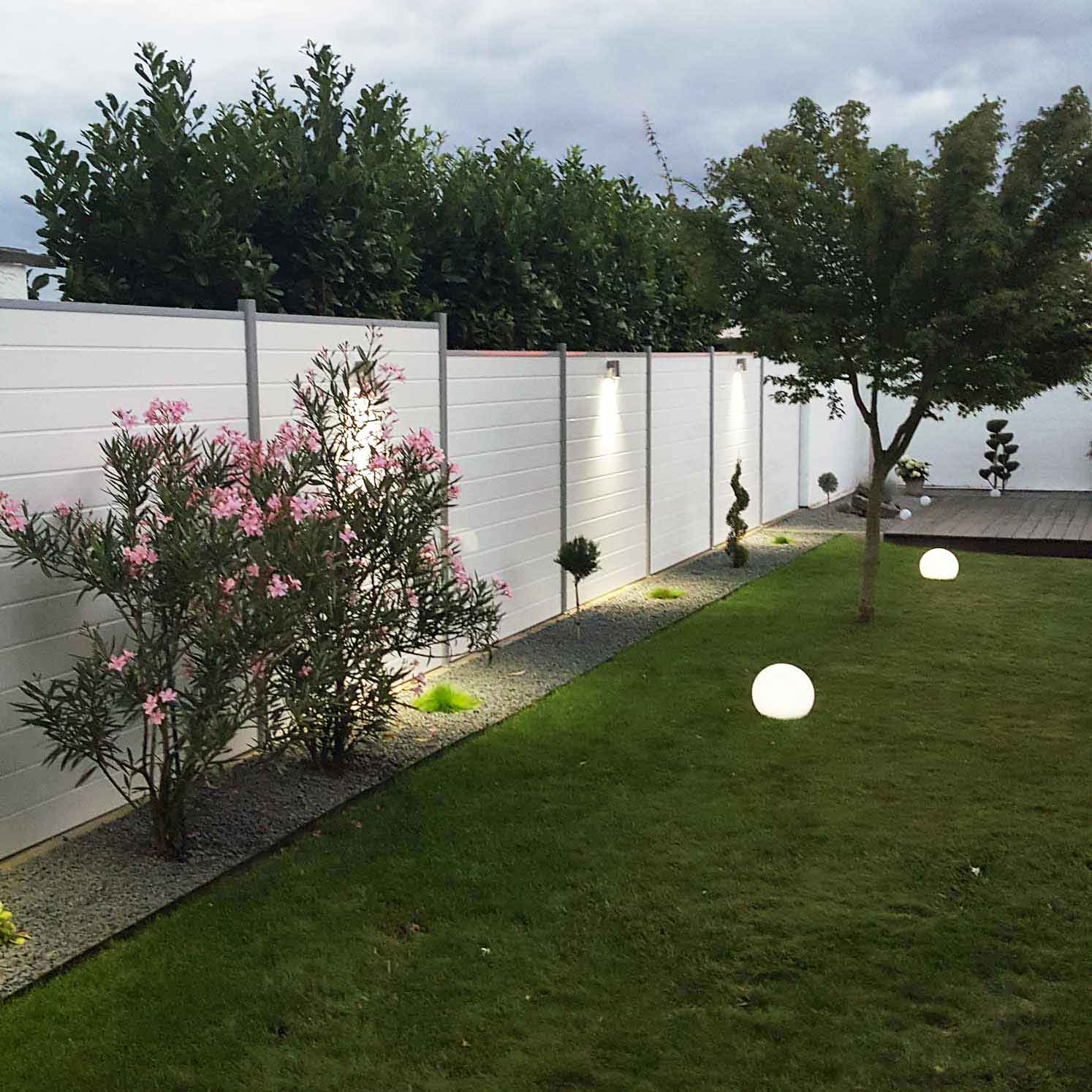 sichtschutzzaun im garten aus Kunststoff in weiß mit steckpfosten