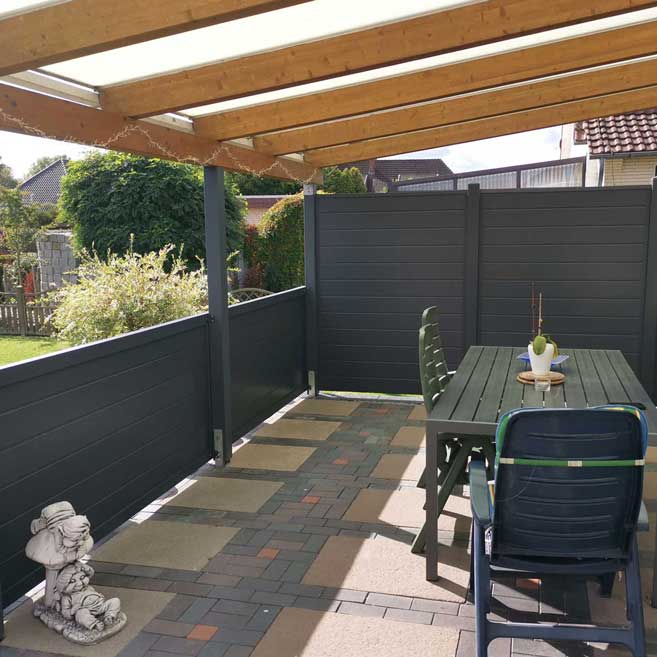 Sichtschutzzaun aus Kunststoff PVC in Anthrazit in verschiedenen Höhen unter einer überdachten Terrasse