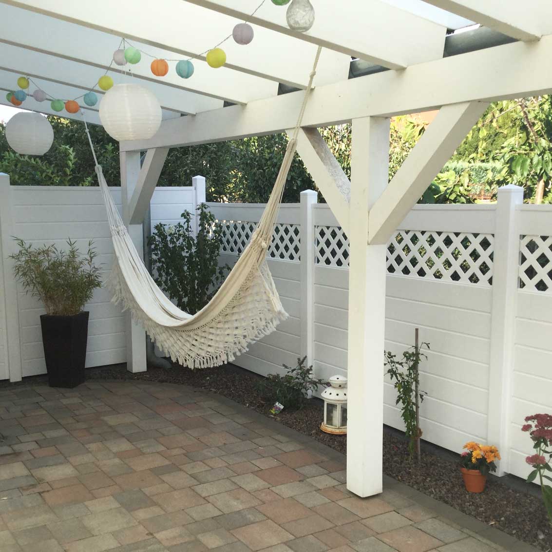  überdachte Terrasse mit Sichtschutz in Weiß und integrierten oberen Rankgitter