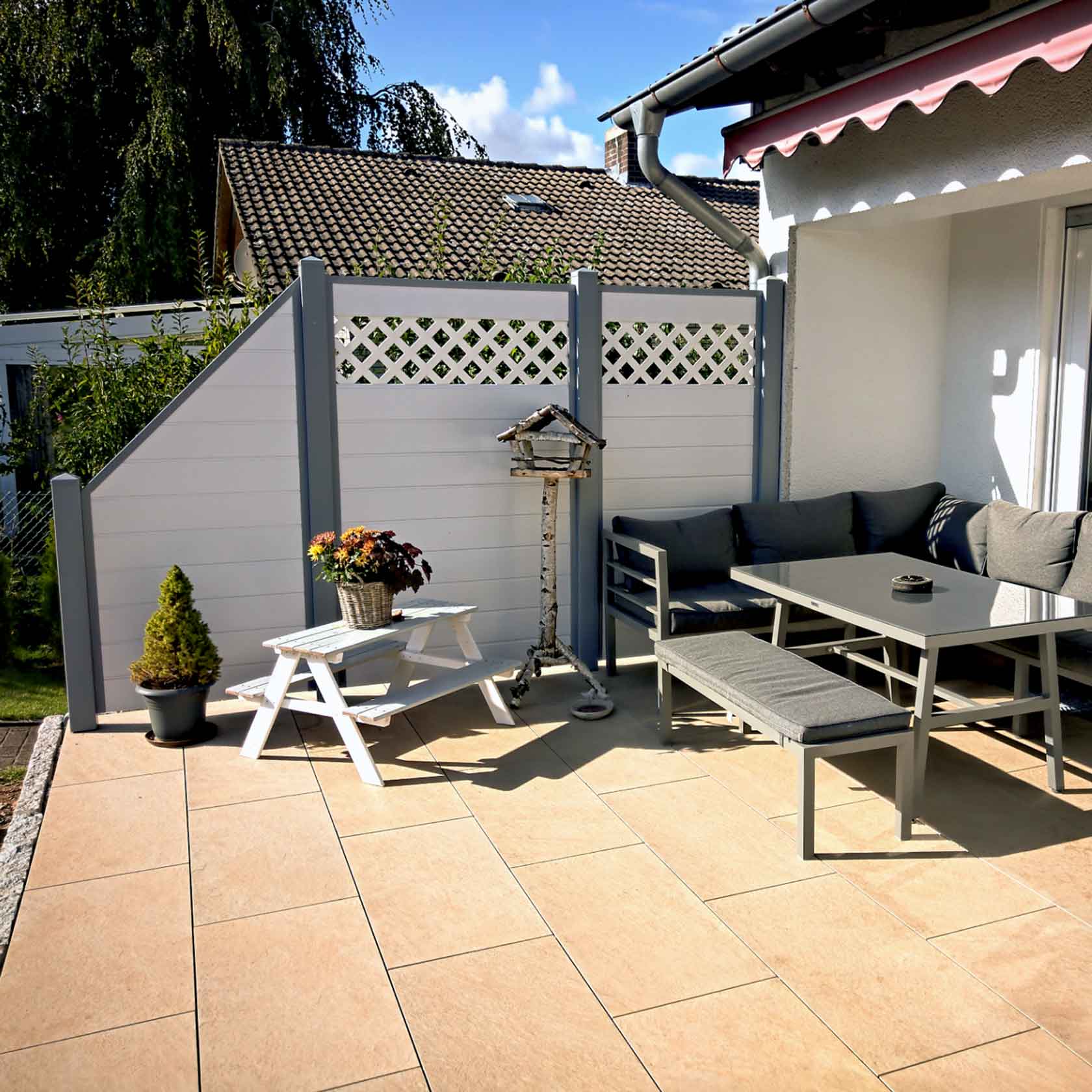 Sichtschutz an einer Terrassenecke aus Kunststoff PVC in Weiß und grauen Pfosten