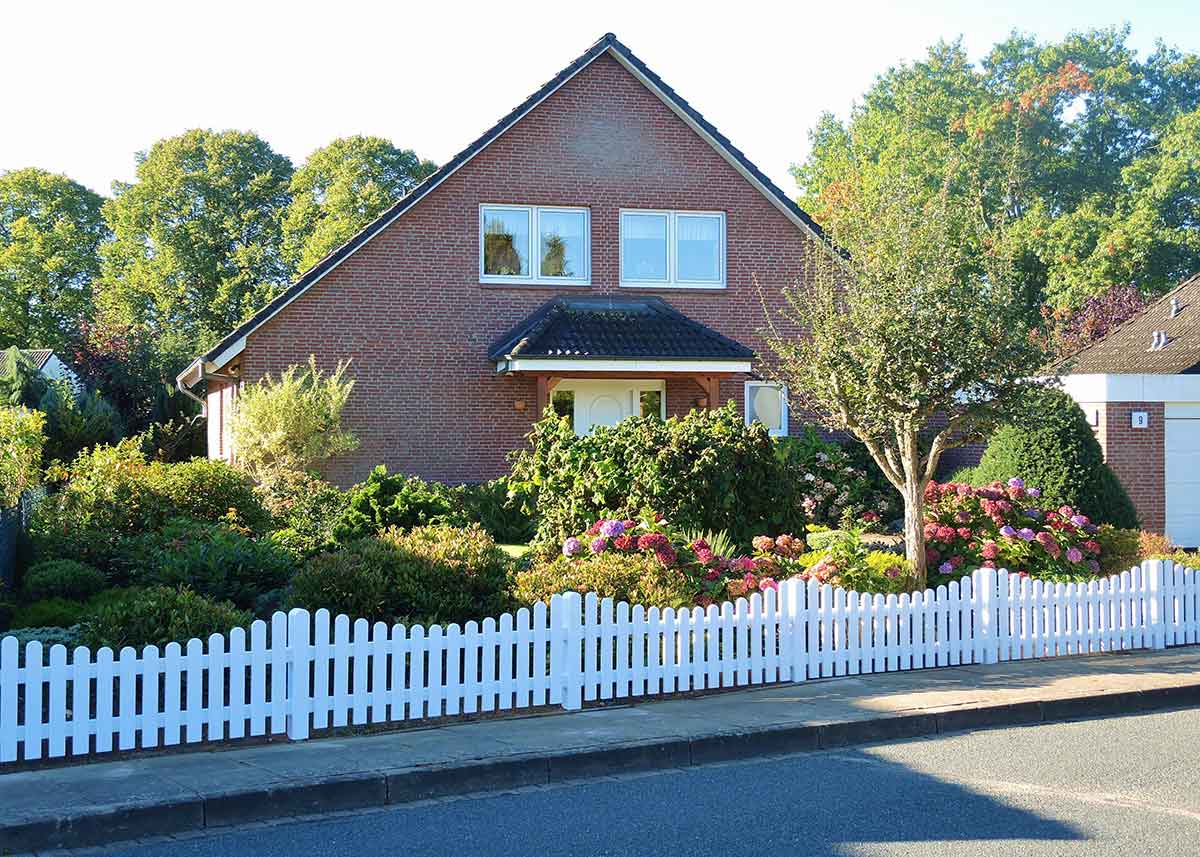 Weißer Vorgartenzaun mit Unterbogen: Klassische Gartenidylle mit Charme und Charakter