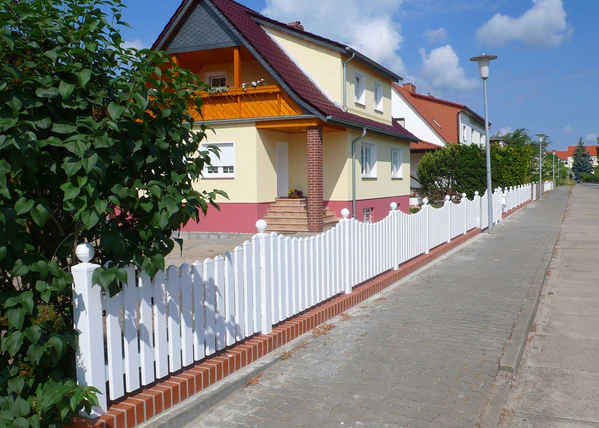 Lattenzaun Gartenzaun in Weiß aus hochwertigen Kunststoff mit Unterbogen und Kugelkappen auf Pfosten