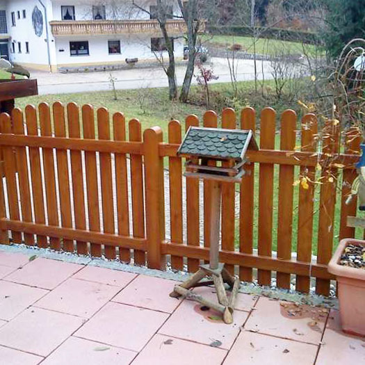 Lattenzaun in echter Holzoptik Golden Oak mit Oberbogen auf Terrasse