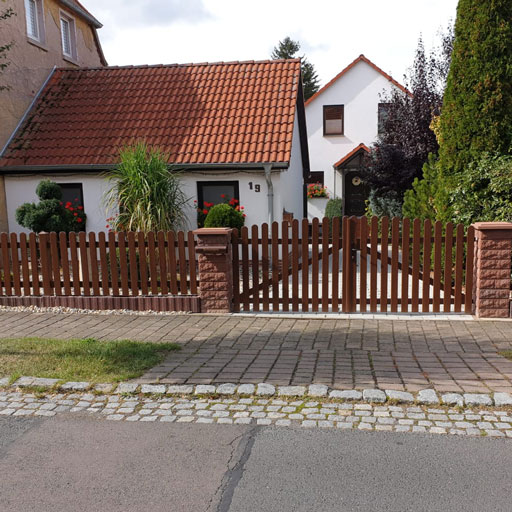 Lattenzaun in Nussbaum mit großen Doppelhoftor