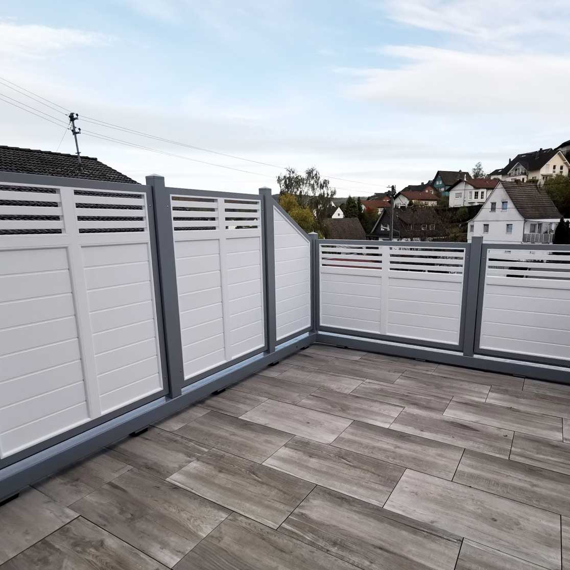Designsichtschutz dicht mit oberen Rhombusgitter, in verschiedenen Höhen in Weiß und Grau, auf einer Dachterrasse